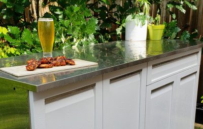 beer and wings on stainless countertop on rain day
